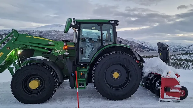 Grønn traktor som strør 
